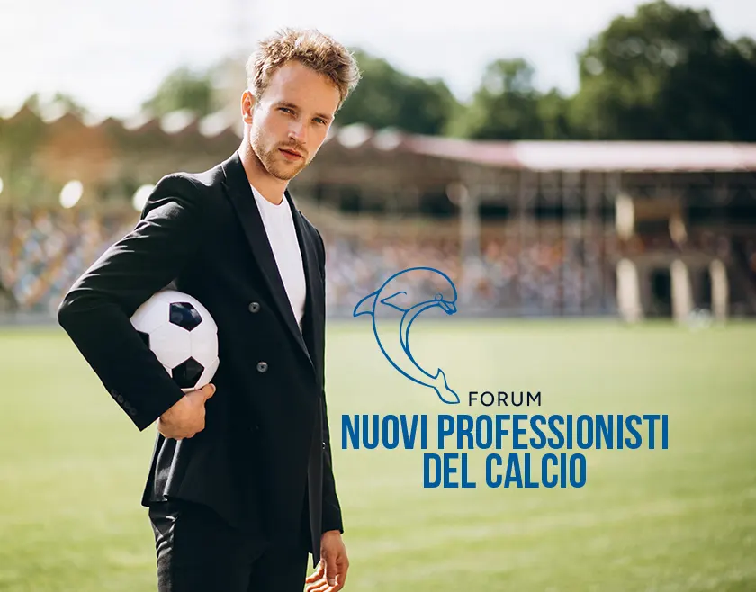 Un giovane businessman con pallone sotto il braccio su un campo di calcio